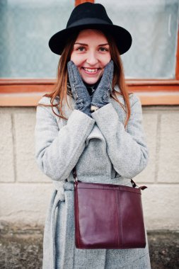 Genç kız bir gri ceket ve deri handb ile siyah şapka modeli