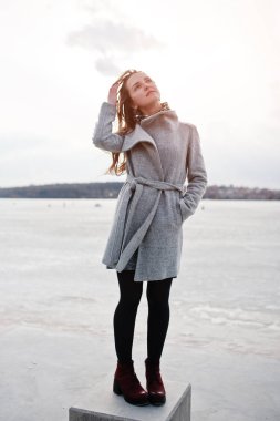 Gri paltolu donma karşı taş küp üzerinde yarattığı genç model kız