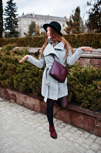 Junges Model-Mädchen in grauem Mantel und schwarzem Hut mit Lederhandgriff — Stockfoto