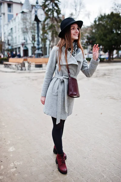 Young model tourist girl in a gray coat and black hat with leath — Stock Photo, Image