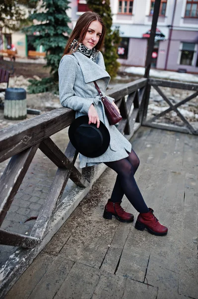 Young model girl in gray coat and black hat with leather handbag — Stock Photo, Image