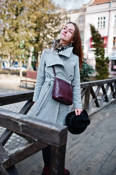Junges Model Mädchen in grauem Mantel und schwarzem Hut mit Lederhandtasche — Stockfoto