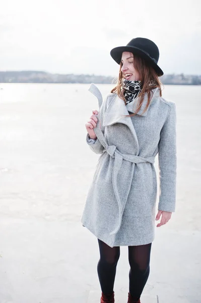 Молодая модель девушка в сером пальто и черной шляпе позировала против Фриза — стоковое фото