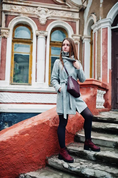 Young model girl in a gray coat with leather handbag on shoulder — Stock Photo, Image