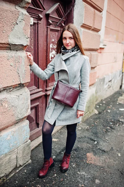 Young model girl in a gray coat with leather handbag on shoulder — Stock Photo, Image
