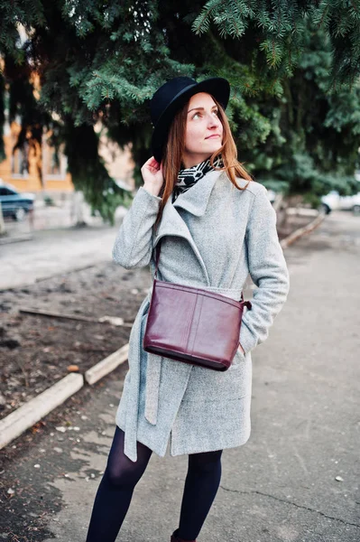 Jeune fille modèle dans un manteau gris et chapeau noir avec poignée en cuir — Photo