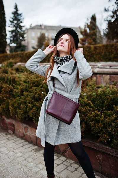 Jeune fille modèle dans un manteau gris et chapeau noir avec poignée en cuir — Photo