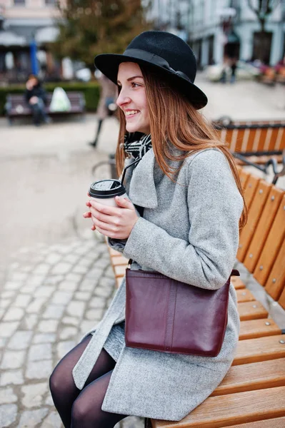 Young model girl in a gray coat and black hat with leather handb — Stock Photo, Image