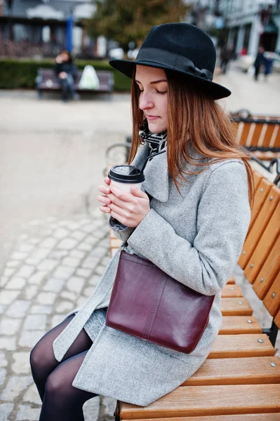 Young model girl in a gray coat and black hat with leather handb — Stock Photo, Image