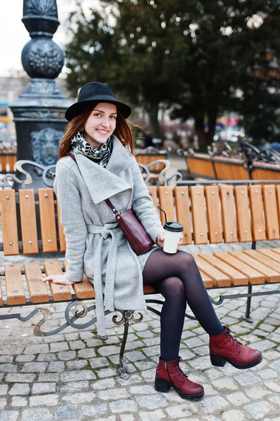Jeune fille modèle dans un manteau gris et chapeau noir avec poignée en cuir — Photo