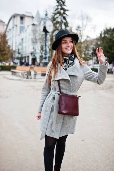 Young model tourist girl in a gray coat and black hat with leath — Stock Photo, Image