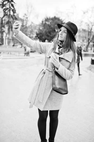 Young model girl in a gray coat and black hat with leather handb — Stock Photo, Image