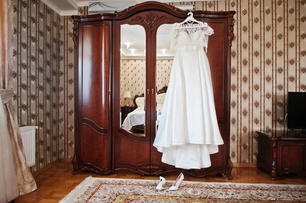 Witte luxe trouwjurk op hangers op houten kast op hotel — Stockfoto