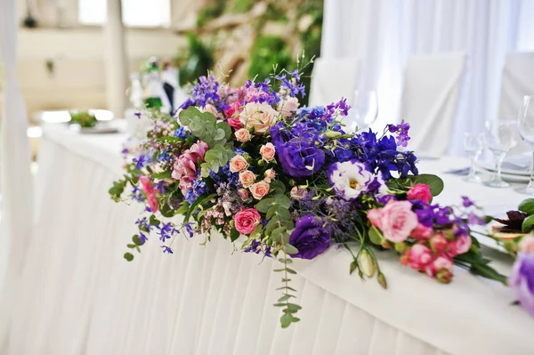 Fialové a purpurové květy na úžasné svatební stůl. — Stock fotografie