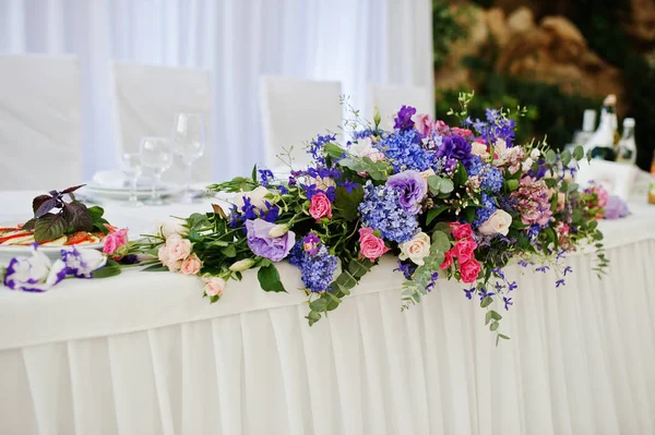 Violette und lila Blumen auf dem Hochzeitstisch. — Stockfoto