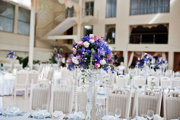 Фиолетовые и фиолетовые цветы за потрясающим свадебным столом . — стоковое фото