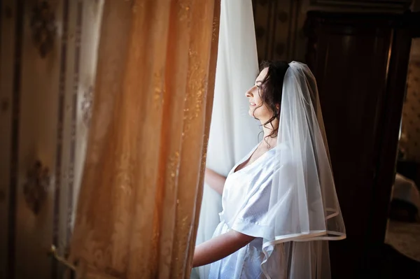 Brunette mariée regardant la fenêtre sur la chambre d'hôtel le matin weddin — Photo