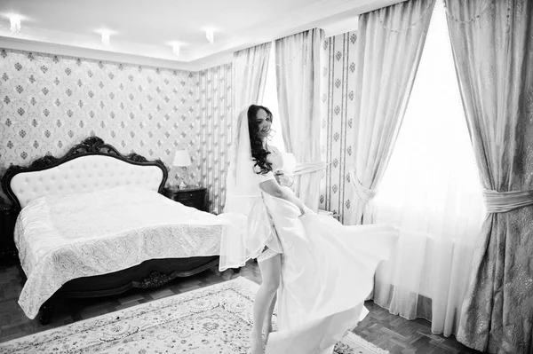 Brunette noiva em um roupão de banho com vestido no quarto de hotel de manhã — Fotografia de Stock
