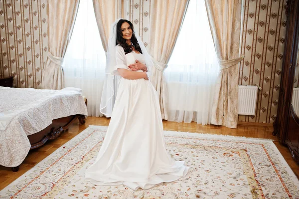 Брюнетка невеста в халате с платьем в номере отеля по утрам — стоковое фото