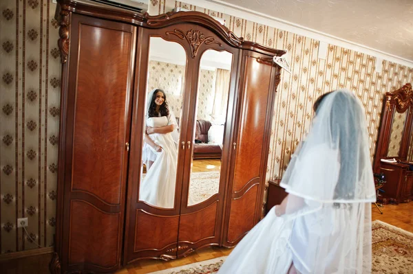 Brunette bride in a bathrobe with dress on hotel room at morning — Stock Photo, Image