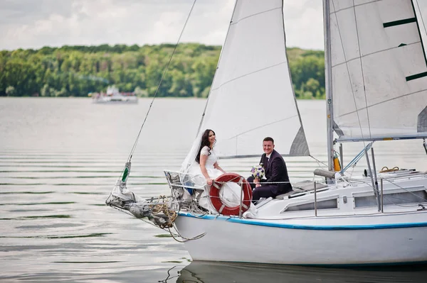 Hochzeitspaar verliebt auf kleiner Segelboot-Jacht am See. — Stockfoto