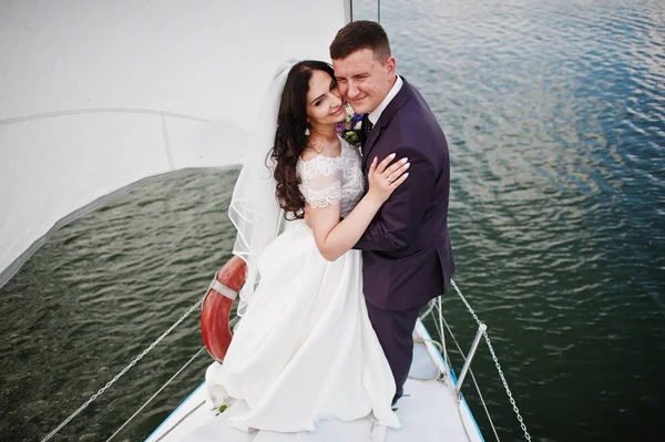 Весільна пара закохана в маленьку вітрильну яхту на озері . — стокове фото