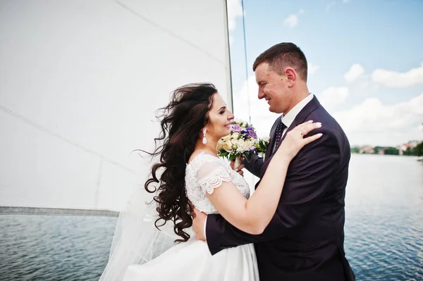 Bröllop par i kärlek vid liten segelbåt yacht på sjön. — Stockfoto