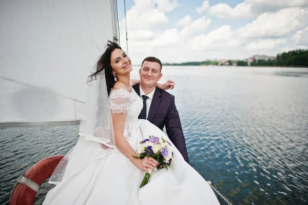 Hochzeitspaar verliebt auf kleiner Segelboot-Jacht am See. — Stockfoto