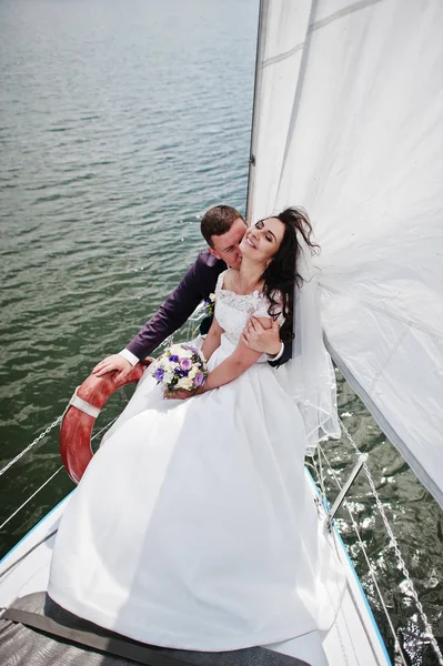 Hochzeitspaar verliebt auf kleiner Segelboot-Jacht am See. — Stockfoto