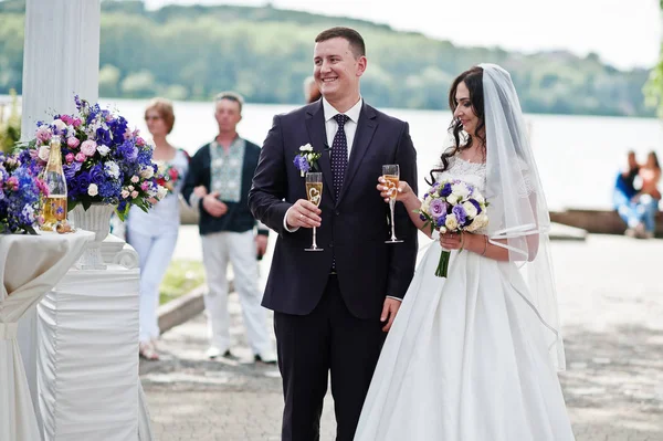 Свадебная пара с бокалами шампанского на свадьбе . — стоковое фото