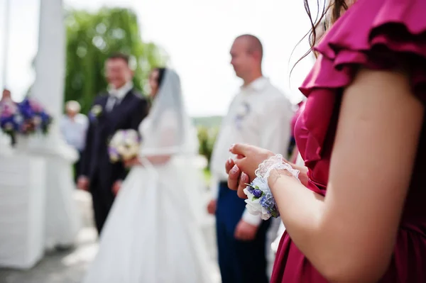 Hands of bridesmaid against wedding couple on wedding ceremony. — Stock Photo, Image