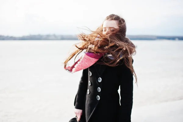 Alkalmi fiatal lány fekete kabátot, a sálat és a kalap ellen fagyasztott ri — Stock Fotó