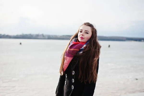 Casual jeune fille à manteau noir, écharpe et chapeau contre ri congelé — Photo