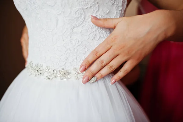 Handen met manicure van bruid op jurk op de huwelijksdag. — Stockfoto