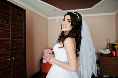 Genç esmer gelin odasına düğün sabahı hazırlanıyor.