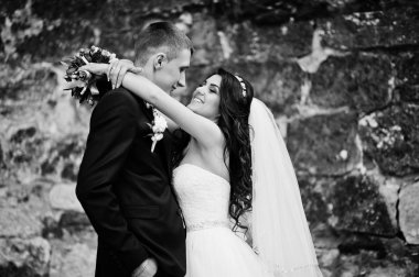 Eski taş duvara genç şık Düğün çifti. Siyah ve w