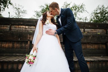 Şık damat ve geline düğün günü, ahşap Kürsü.