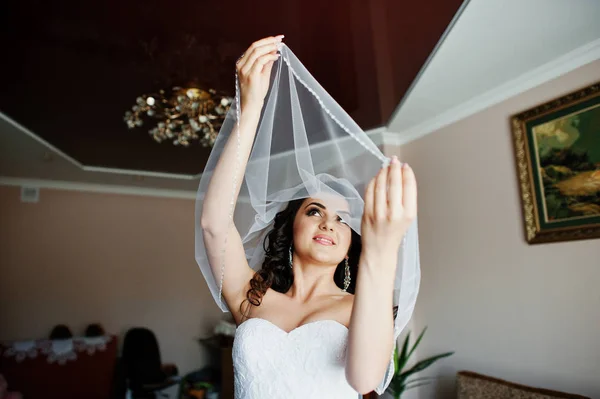 Jovem noiva morena se preparando em seu quarto na manhã do casamento . — Fotografia de Stock