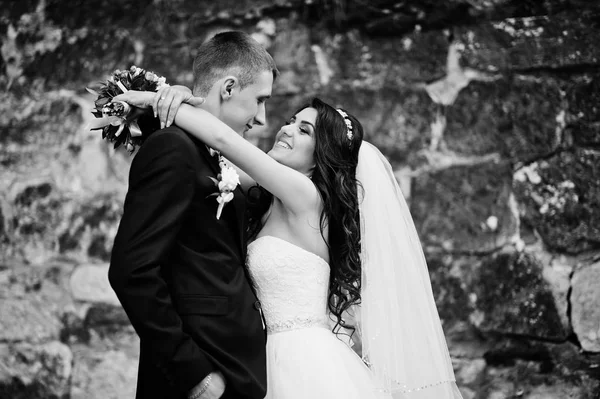 Casal de casamento elegante jovem contra parede de pedra velha. Preto e w — Fotografia de Stock