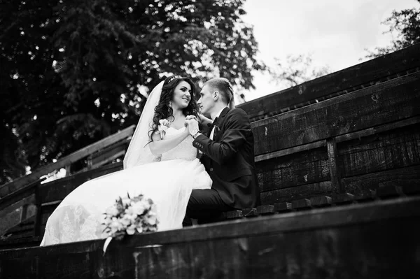 Stylish groom and bride at wooden tribune at their wedding day. — Stock Photo, Image