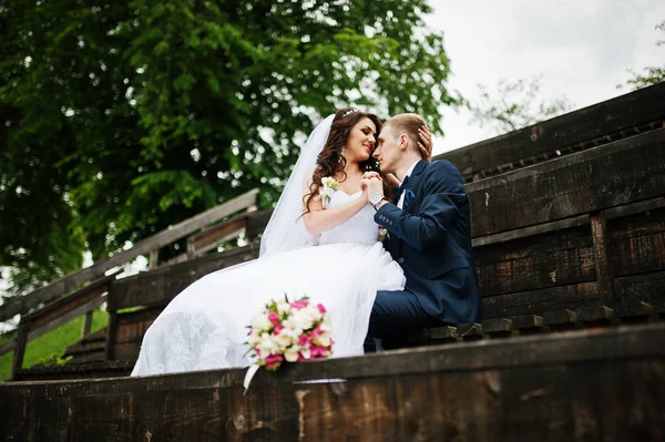 Stylový ženich a nevěsta na dřevěných tribun na jejich svatební den. — Stock fotografie
