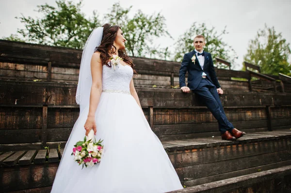 Noivo elegante e noiva no tribuno de madeira no dia do casamento . — Fotografia de Stock