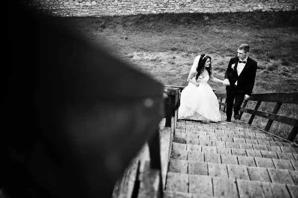 Stylish groom and bride at wooden tribune at their wedding day. — Stock Photo, Image