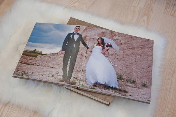 Pages of wedding photobook or wedding album at carpet on wooden — Stock Photo, Image