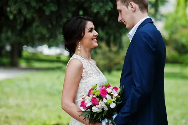 Happy stijlvolle hield paar verliefd op de achtergrond van de groene lente. — Stockfoto