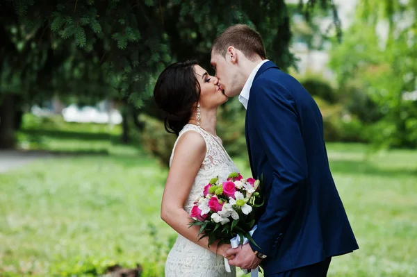 Happy stylish loved couple kisses in love at green spring backgr — Stock Photo, Image