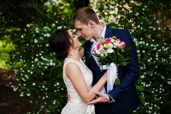 Gelukkige stijlvolle geliefd paar kusjes in liefde op het groene lente backgr — Stockfoto