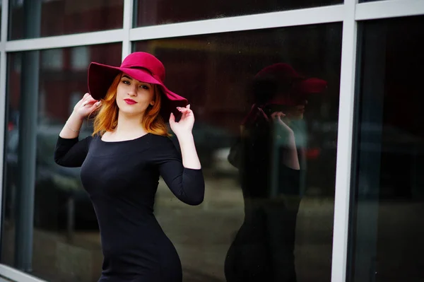 Портрет модной рыжеволосой девушки в красной шляпе и черном платье — стоковое фото