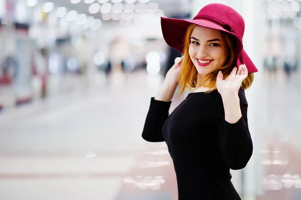 Moda chica pelirroja desgaste en vestido negro y sombrero rojo posado en — Foto de Stock