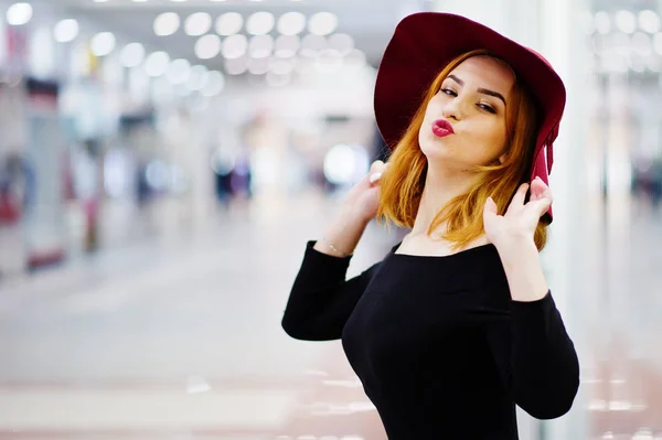 Moda chica pelirroja desgaste en vestido negro y sombrero rojo posado en — Foto de Stock